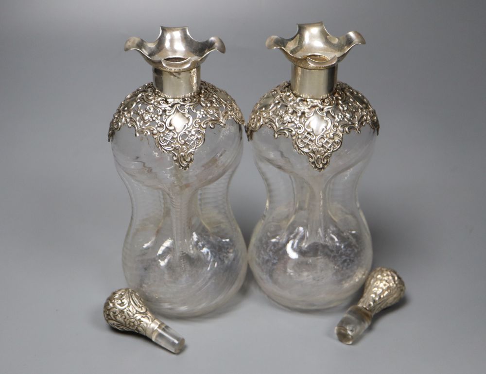 A pair of Edwardian pierced silver mounted waisted decanters, Henry Matthews, Birmingham, 1906